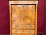 une commode ancienne en bois avec un plateau en marbre, dans une pièce aux murs rouges