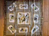 a scarf with pictures of insects on it on a wooden floor