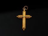 un pendentif en forme de croix en or sur fond noir