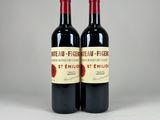 two bottles of red wine sitting next to each other on a table