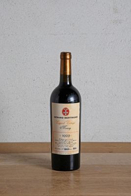 une bouteille de vin rouge posée sur une table en bois