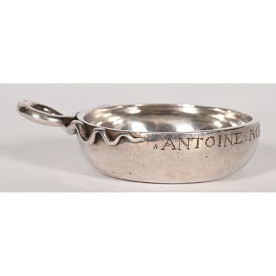 an antique silver plate with a spoon and handle