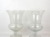 two clear glass vases sitting on a white surface