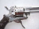 a silver revolver on a white surface with a black handle