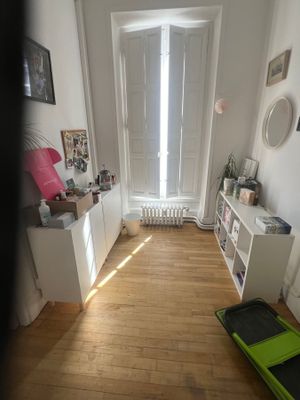 une petite pièce avec un parquet et un radiateur blanc