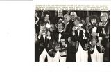 a black and white photo of a group of men in tuxedos posing for a picture