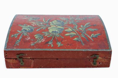 une petite boîte rouge ornée d'un motif floral