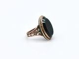a close up of a ring with a black stone on it