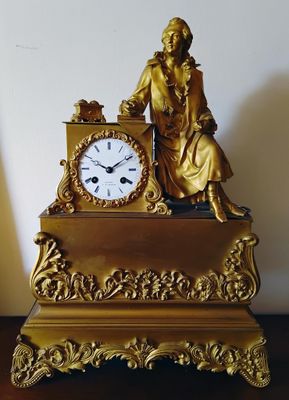 une horloge en or posée sur une table en bois