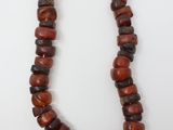 un collier composé de perles rouges et noires, avec une chaîne en argent