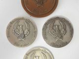three medals are shown on a white surface with a white background