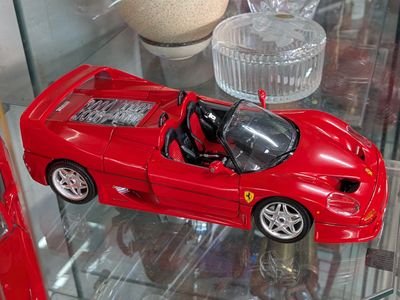 une petite voiture rouge exposée dans une vitrine