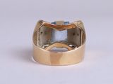 an image of a gold ring with a blue stone in it