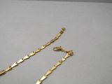 un gros plan sur une paire de bracelets à chaîne en or posés sur une table