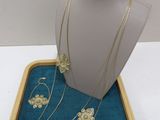 necklace and earring set in a box on a white surface