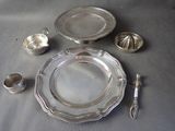 a silver plate and silver spoons on a table