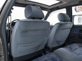 two seats in the back of a truck with blue covers
