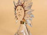 a glass sculpture of a sun with a face on it