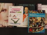 plusieurs livres posés sur une table noire, surmontés d'une couronne dorée