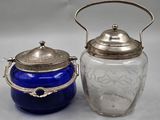 two blue glass jars with silver lids on a table