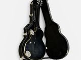 two guitars that are sitting side by side on a white surface