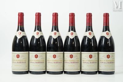 six bottles of wine are lined up on a white surface