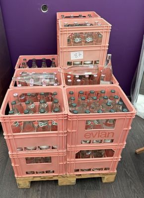 several crates of soda bottles are stacked on top of each other