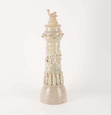 une photo d'un petit phare blanc surmonté d'un oiseau