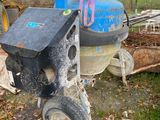 a machine that is sitting on the ground next to a pile of wood