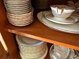 de nombreuses assiettes et bols posés sur une étagère dans un placard