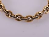 a close up of a gold chain bracelet on a white surface