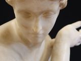 marble statue of a young girl holding a flower in her right hand