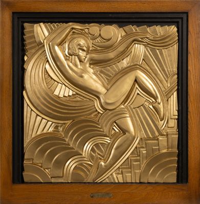 an art deco plaque depicting a woman on a surfboard in gold