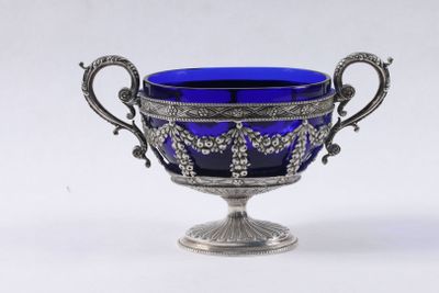 vase en verre argenté et bleu, orné de poignées décorées sur fond blanc