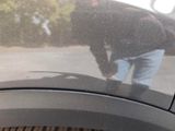 a reflection of a man in the mirror of a car