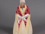 an old figurine of a woman in a red and white dress
