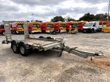 a trailer that is parked in a lot with other trucks