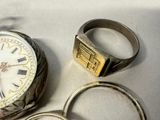two rings and a watch sitting next to each other on a table