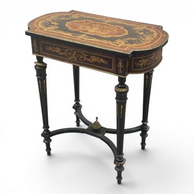 a black and gold painted table with a drawer underneath it