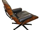 un fauteuil et un repose-pieds en cuir noir sur fond blanc