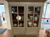 a cabinet with a glass door in the middle of a room
