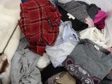 a pile of clothes that is sitting on a bed