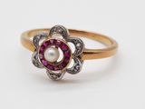 gros plan d'une bague en or avec une perle au centre
