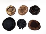 several different hats are lined up on a white surface