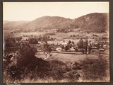 a black and white photo of a small town in the mountains