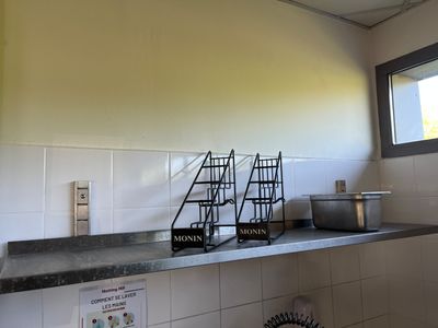 une cuisine équipée d'une cuisinière, d'un évier et d'une fenêtre