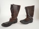 pair of brown leather boots with laces on them on a white surface