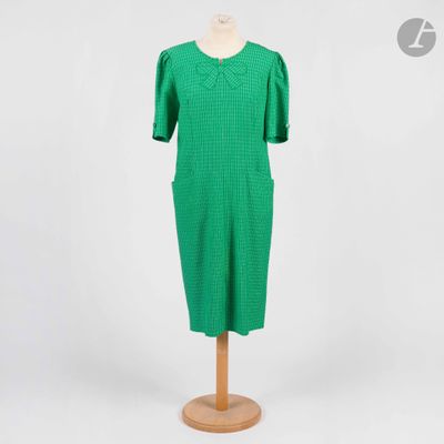 une robe verte posée sur un présentoir à mannequin, sur fond blanc