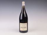 une vieille bouteille de vin posée sur une table blanche