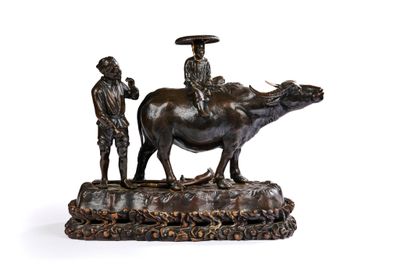 statue en bronze représentant un homme chevauchant une vache, avec un autre homme debout à côté